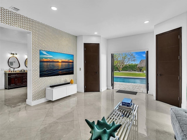 interior space with baseboards, an accent wall, and recessed lighting