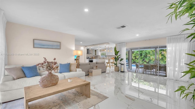 living area with recessed lighting, marble finish floor, and visible vents