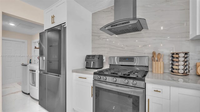 kitchen featuring appliances with stainless steel finishes, tasteful backsplash, range hood, washer / dryer, and white cabinetry
