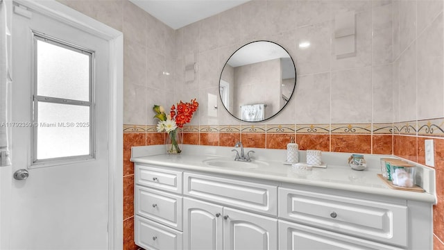 bathroom with vanity and tile walls