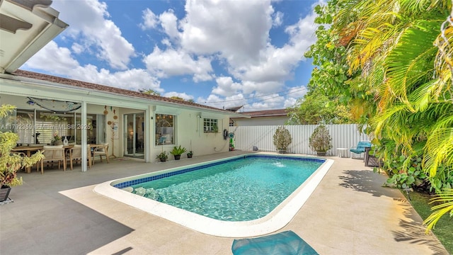 view of pool with fence, a fenced in pool, outdoor dining area, and a patio