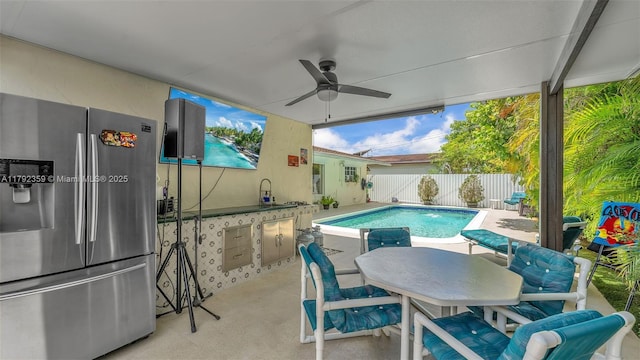 view of pool featuring outdoor dining area, a ceiling fan, a patio area, and fence
