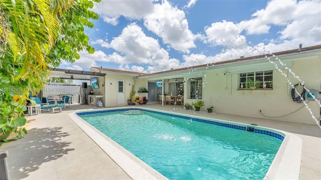 outdoor pool with a patio and fence