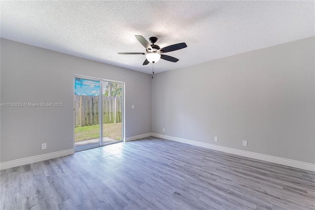 spare room with baseboards, a ceiling fan, a textured ceiling, and wood finished floors