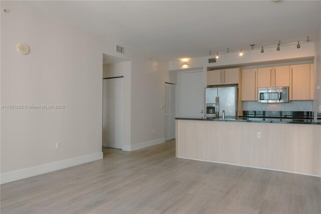 79 SW 12th St Unit 1403-S, Miami, FL 33130 - kitchen featuring light brown cabinetry, dark countertops, appliances with stainless steel finishes, light wood-style floors, and visible vents