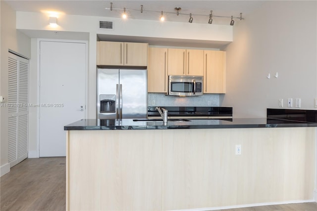 79 SW 12th St Unit 1403-S, Miami, FL 33130 - kitchen with visible vents, decorative backsplash, light brown cabinetry, a sink, and appliances with stainless steel finishes