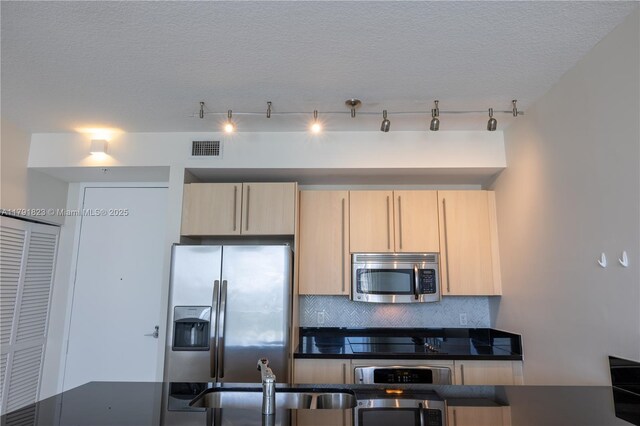 79 SW 12th St Unit 1403-S, Miami, FL 33130 - kitchen featuring light brown cabinetry, dark countertops, appliances with stainless steel finishes, tasteful backsplash, and visible vents
