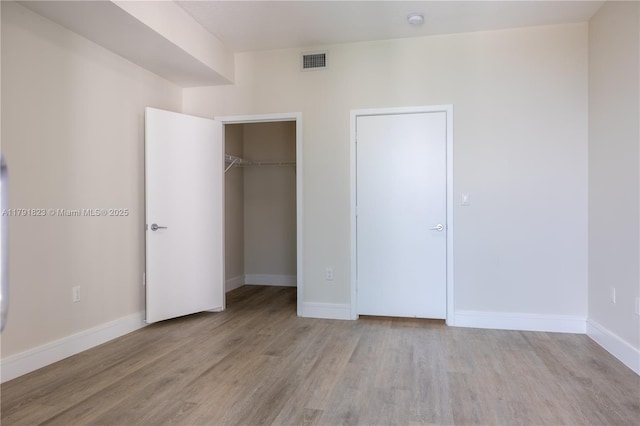 79 SW 12th St Unit 1403-S, Miami, FL 33130 - unfurnished bedroom with visible vents, baseboards, wood finished floors, and a closet