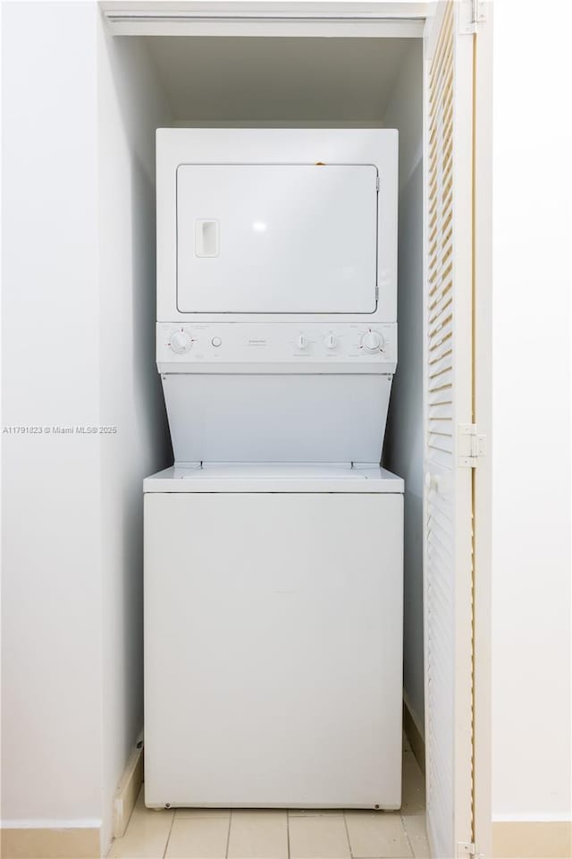 79 SW 12th St Unit 1403-S, Miami, FL 33130 - laundry area with light tile patterned flooring, stacked washer / drying machine, baseboards, and laundry area