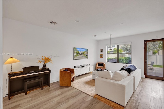 living area featuring light wood-style floors and visible vents