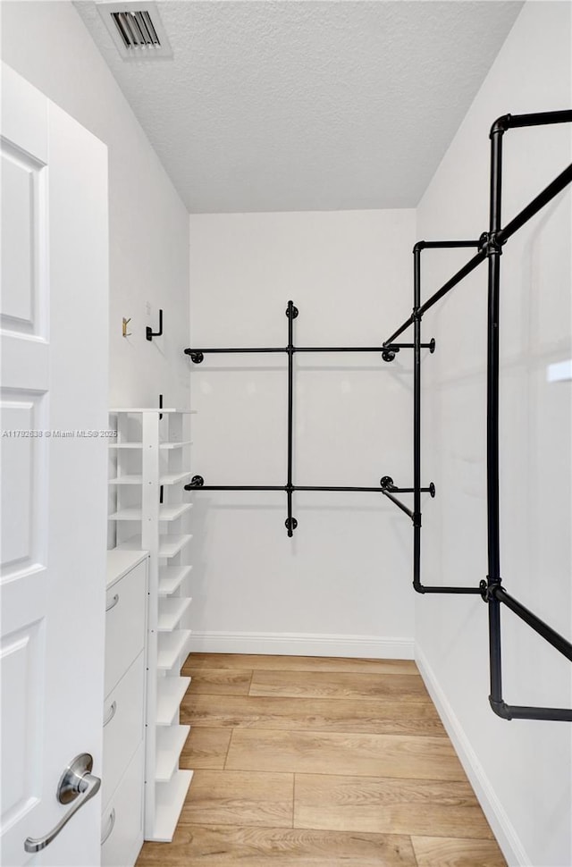 spacious closet featuring visible vents and light wood-style flooring