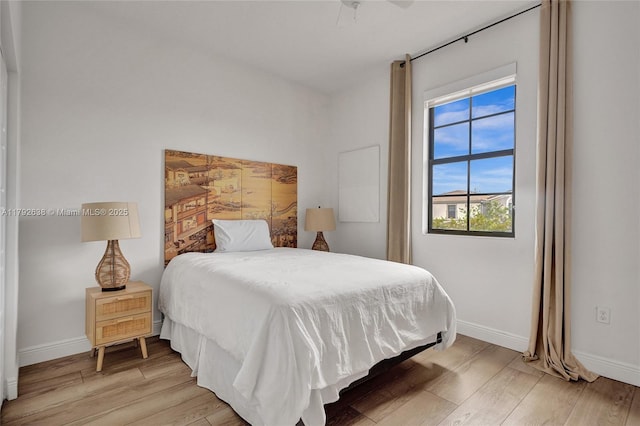 bedroom with light wood-style floors and baseboards