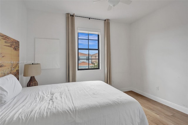 bedroom with baseboards, light wood finished floors, and ceiling fan