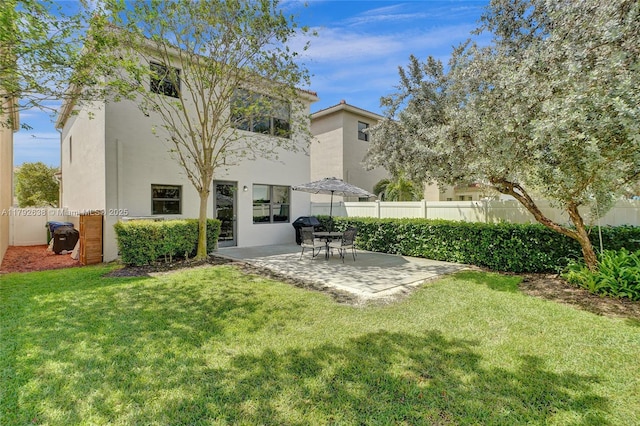 rear view of house with a yard, a patio, fence, and stucco siding