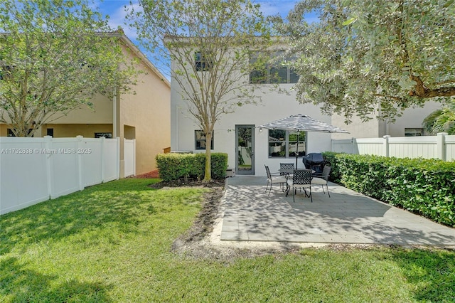 back of house featuring a lawn, fence, stucco siding, and a patio area