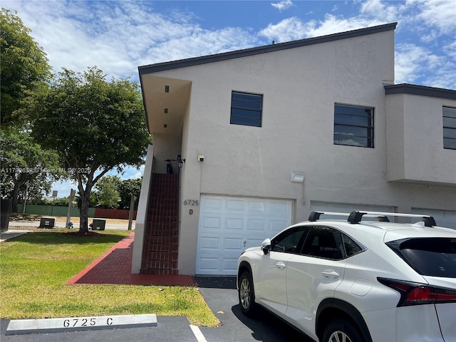 view of property exterior with a lawn, uncovered parking, and stucco siding