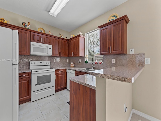 kitchen featuring backsplash, a sink, light tile patterned floors, a peninsula, and white appliances
