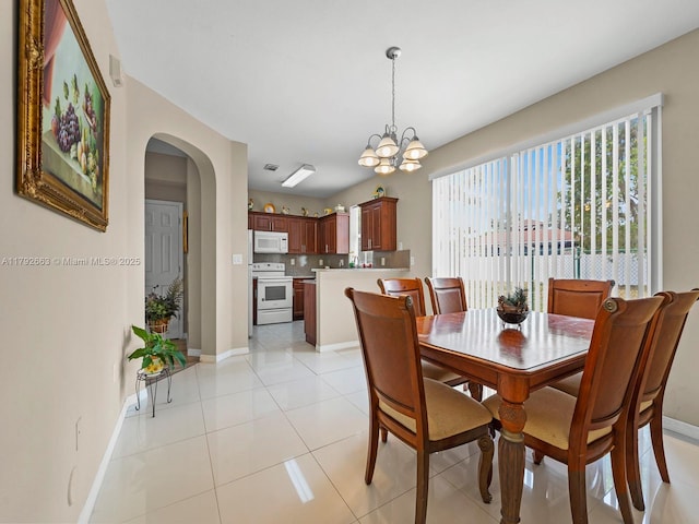 dining area featuring arched walkways, baseboards, an inviting chandelier, and light tile patterned floors