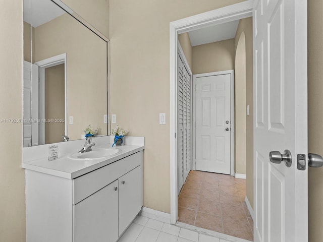 bathroom with vanity, tile patterned flooring, and baseboards