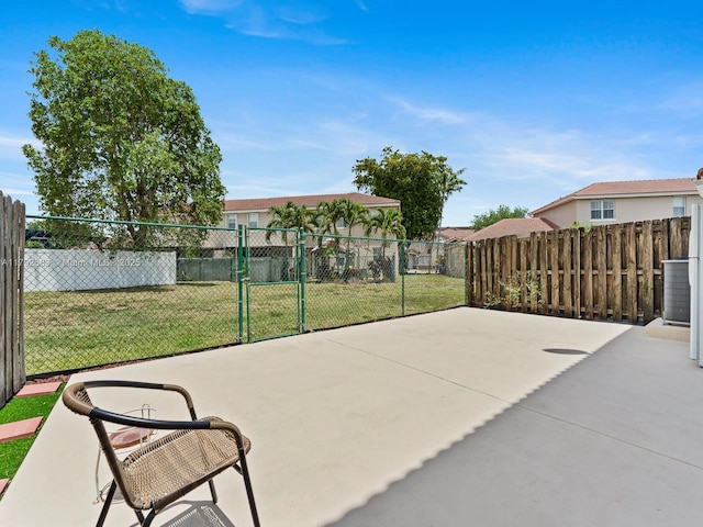 view of patio / terrace featuring central AC, fence, and a gate