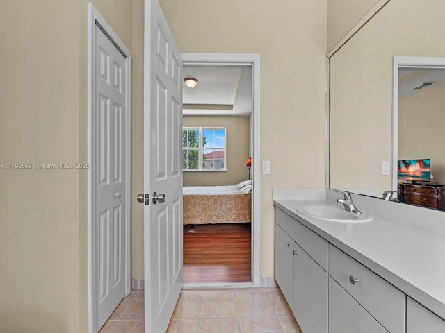 ensuite bathroom with tile patterned flooring, vanity, baseboards, a closet, and connected bathroom