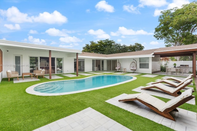 view of swimming pool with a fenced in pool, fence, a patio, and a lawn