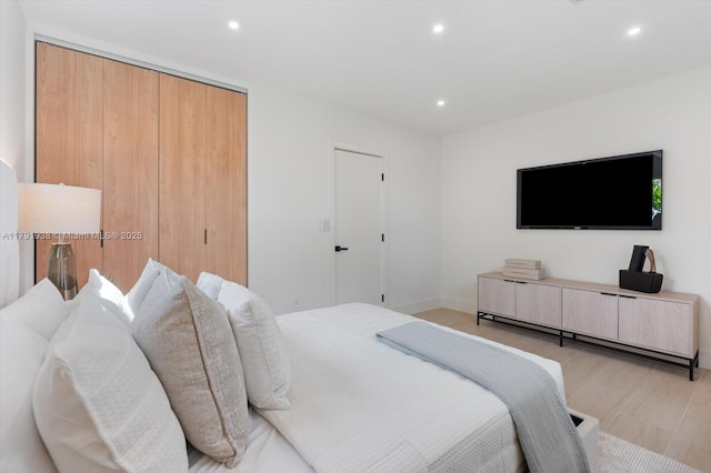 bedroom featuring recessed lighting, light wood finished floors, baseboards, and a closet