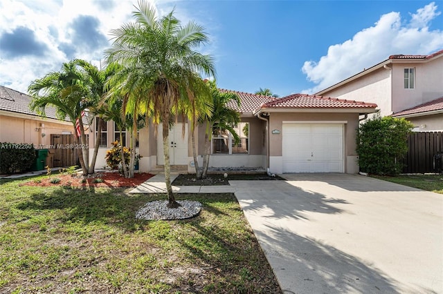 mediterranean / spanish house featuring fence, an attached garage, a tile roof, stucco siding, and concrete driveway