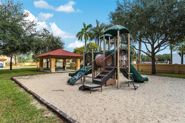 community jungle gym with a gazebo, a lawn, and fence