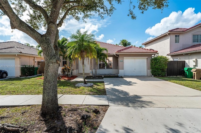 view of front facade with a garage, fence, stucco siding, concrete driveway, and a tile roof