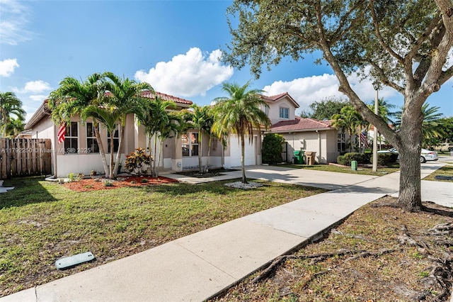 view of front of house with an attached garage, a front lawn, fence, and concrete driveway