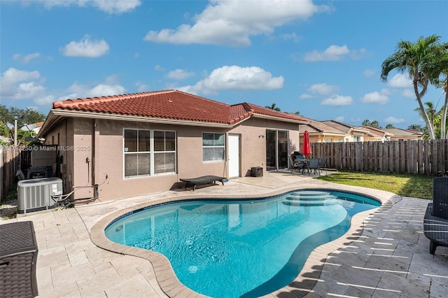 back of property with central AC unit, stucco siding, a patio area, and a tiled roof