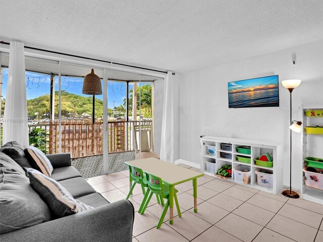1780 NE 191st St Unit 205-2, Miami, FL 33179 - tiled living area featuring a textured ceiling and baseboards
