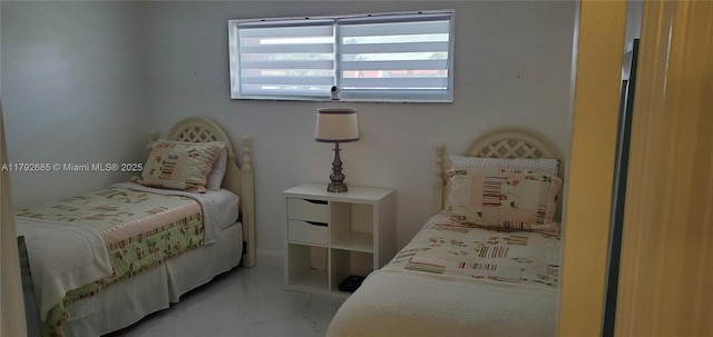 bedroom featuring marble finish floor