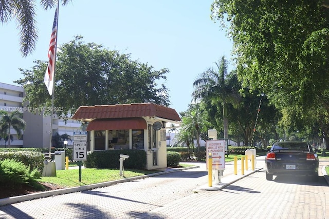 view of street featuring traffic signs, a gated entry, and curbs