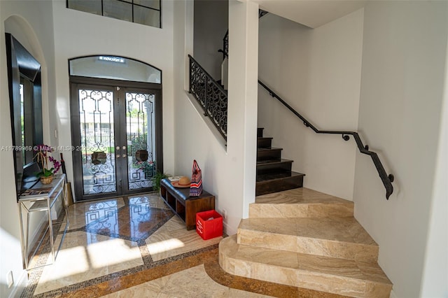 260 NE Wavecrest Ct, Boca Raton, FL 33432 - foyer featuring marble tiled flooring, stairs, french doors, inlaid floor details, and a towering ceiling
