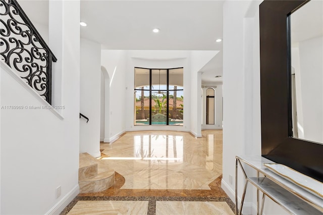 260 NE Wavecrest Ct, Boca Raton, FL 33432 - corridor featuring marble tiled flooring, arched walkways, inlaid floor details, stairway, and recessed lighting