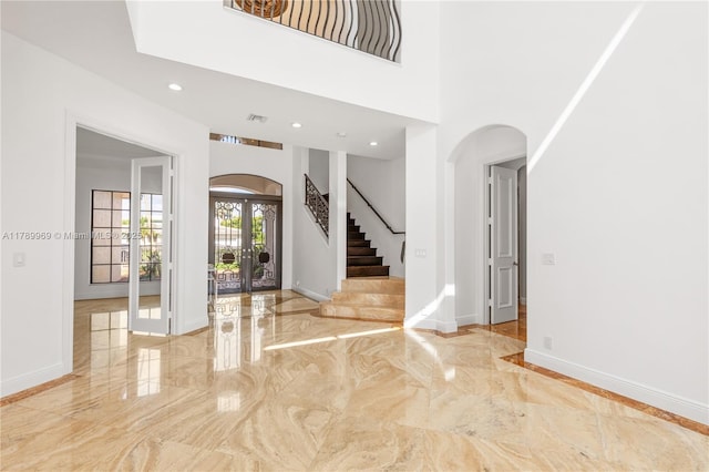 260 NE Wavecrest Ct, Boca Raton, FL 33432 - entrance foyer featuring french doors, marble tiled floors, arched walkways, stairway, and recessed lighting