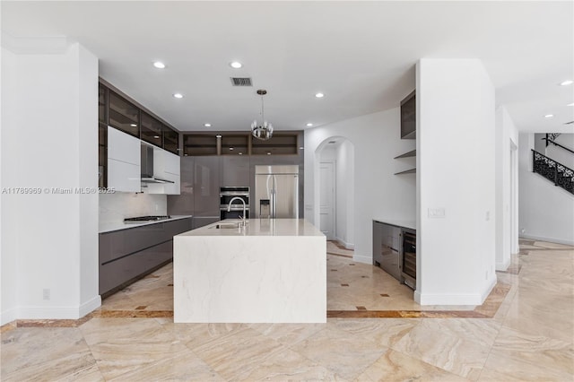 260 NE Wavecrest Ct, Boca Raton, FL 33432 - kitchen featuring appliances with stainless steel finishes, modern cabinets, arched walkways, light marble finish flooring, and open shelves