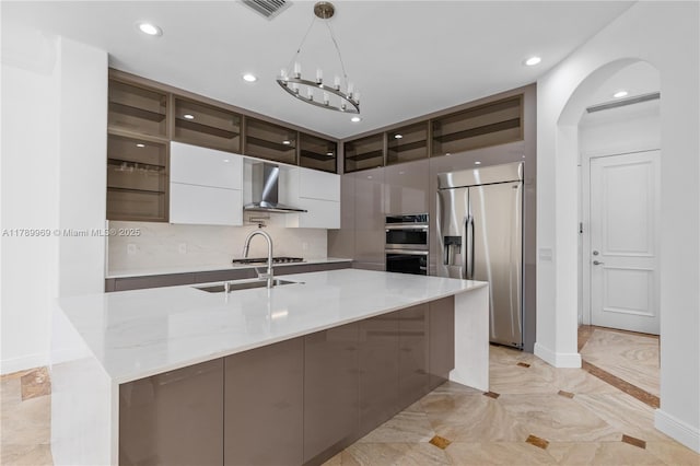 260 NE Wavecrest Ct, Boca Raton, FL 33432 - kitchen with appliances with stainless steel finishes, wall chimney range hood, modern cabinets, arched walkways, and hanging light fixtures