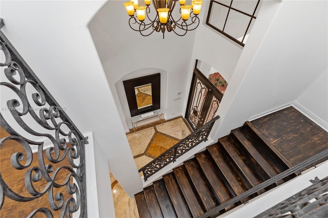 260 NE Wavecrest Ct, Boca Raton, FL 33432 - stairs featuring a high ceiling, a chandelier, and arched walkways