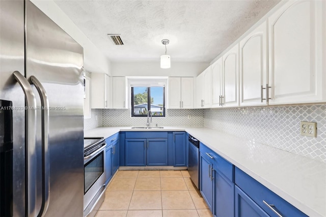 6451 Coolidge St, Hollywood, FL 33024 - kitchen featuring a sink, blue cabinetry, white cabinetry, and stainless steel appliances