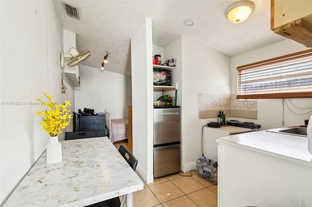 6451 Coolidge St, Hollywood, FL 33024 - kitchen featuring visible vents, light countertops, light tile patterned floors, a sink, and freestanding refrigerator