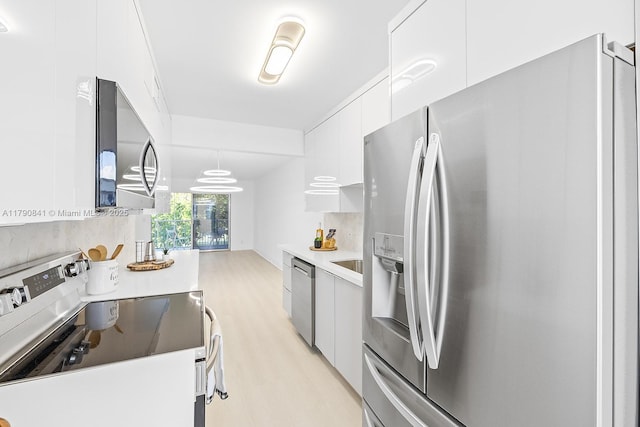 kitchen with modern cabinets, light wood-style flooring, stainless steel appliances, and white cabinetry