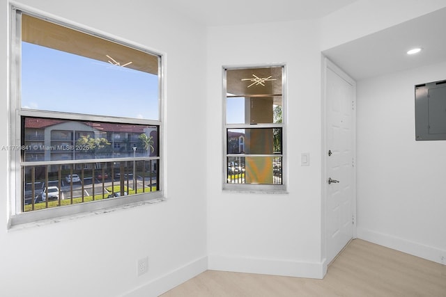 unfurnished room with baseboards, plenty of natural light, and wood finished floors