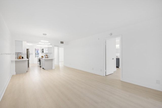 13000 SW 15th Ct Unit 310U, Pembroke Pines, FL 33027 - unfurnished living room with light wood finished floors, baseboards, and visible vents