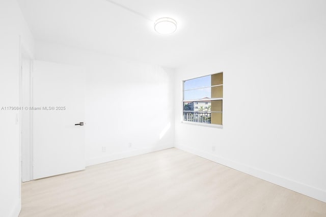 unfurnished room with baseboards and light wood-style flooring