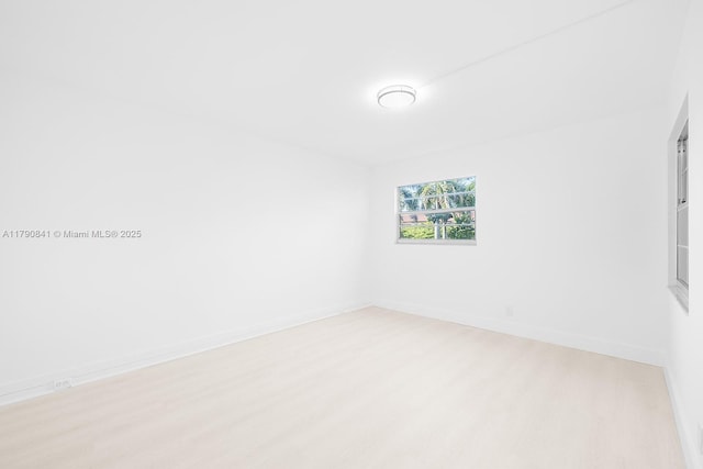 unfurnished room with baseboards and wood finished floors