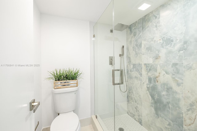 full bath featuring baseboards, a stall shower, and toilet