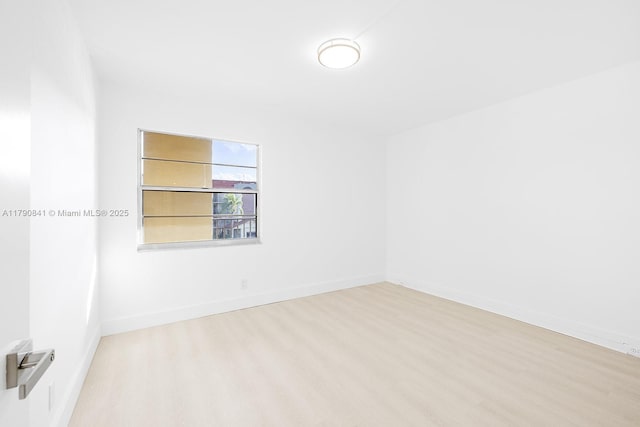 unfurnished room featuring baseboards and wood finished floors